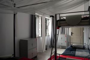 a bedroom with a bunk bed and a bed and a dresser at Lisbon Hostel Terminal 3 in Lisbon