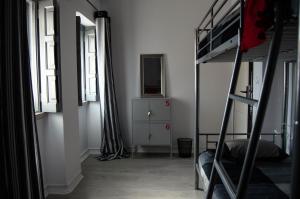 a bedroom with a bunk bed with a dresser and two windows at Lisbon Hostel Terminal 3 in Lisbon