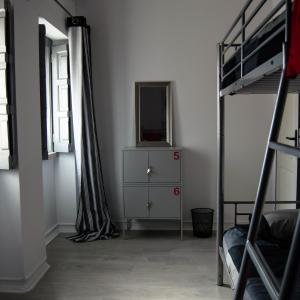 a bedroom with two bunk beds and a dresser and a mirror at Lisbon Hostel Terminal 3 in Lisbon