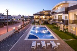 uma vista para um edifício com uma piscina e cadeiras em Lara Beach Homes em Antália