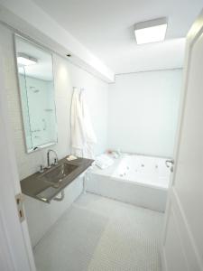 a white bathroom with a tub and a sink at Patios de San Telmo in Buenos Aires