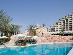 a swimming pool with a resort in the background at Dan Eilat Hotel in Eilat