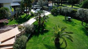 - une vue aérienne sur une cour bordée de palmiers dans l'établissement Hotel Villa Claudia, à Nago-Torbole