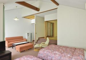 a hotel room with a bed and a living room at Le Nessa Akazawa in Ito