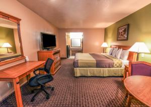 um quarto de hotel com um quarto com uma cama e uma secretária em Chariot Inn Glendale - Pasadena em Glendale