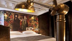 a bedroom with a bed with a painting on the wall at Hotel Le Notre Dame Saint Michel in Paris