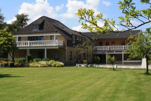 a large brick house with a large yard at Pension Treenehof in Friedrichstadt