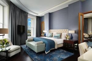 a bedroom with a king sized bed and a living room at Corinthia London in London