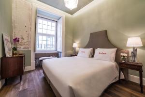 a bedroom with a large white bed and a window at Dare Lisbon House in Lisbon