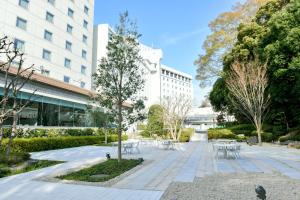 um parque com mesas e cadeiras em frente a um edifício em Narita Tobu Hotel Airport em Narita