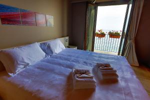 a bedroom with a large bed with two towels on it at Il Casato Deluxe Rooms in Scilla