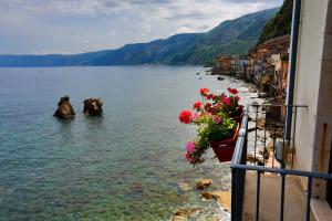 a view of a body of water with buildings and flowers at Il Casato Deluxe Rooms in Scilla