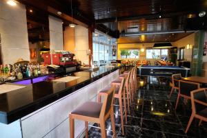 a restaurant with a bar with chairs and tables at Hotel Complejo Los Rosales in Torremolinos