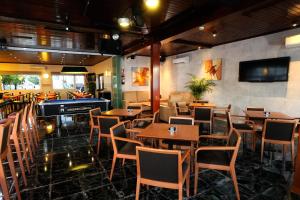 a restaurant with wooden tables and chairs and a flat screen tv at Hotel Complejo Los Rosales in Torremolinos