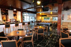 a restaurant with tables and chairs and a bar at Hotel Complejo Los Rosales in Torremolinos