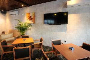 a restaurant with two tables and a tv on a wall at Hotel Complejo Los Rosales in Torremolinos