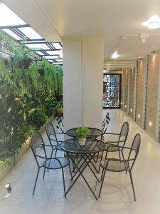 a table and chairs in a room with plants at Bangkok Saran Poshtel in Bangkok