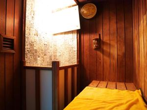 a bedroom with a bed and a clock on the wall at Wisterian Life Club Usami in Ito