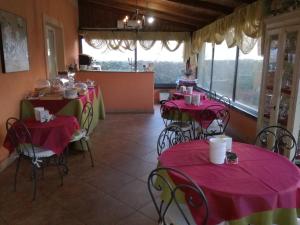 a room with tables and chairs with pink table cloths at Albergo Arinde in Rende