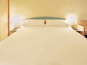 Una cama o camas en una habitación de ibis Augsburg Hauptbahnhof