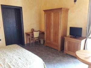 a bedroom with a bed and a tv and a cabinet at Palazzo Marzano in Briatico