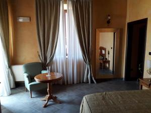 a hotel room with a bed and a table and a chair at Palazzo Marzano in Briatico