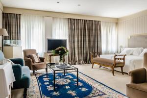 Habitación de hotel con cama y sala de estar. en Gran Hotel La Perla, en Pamplona