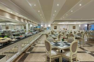 a restaurant with tables and chairs and a buffet at Elite World Istanbul Taksim in Istanbul