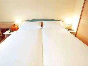 Una cama o camas en una habitación de ibis Augsburg Hauptbahnhof