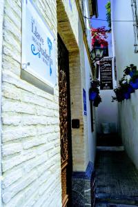 un callejón estrecho con una señal en el lateral de un edificio en La Llave de la Judería Hotel Boutique, en Córdoba