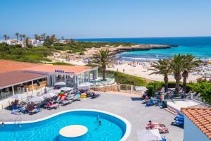 an aerial view of a resort with a pool and a beach at Fergus Style Carema Beach in Cala'n Bosch