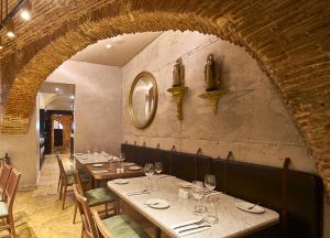 a restaurant with tables and chairs and a brick wall at My Story Hotel Tejo in Lisbon