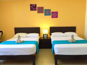 two beds with stuffed animals on them in a room at Hotel Plazha in Tuxtla Gutiérrez