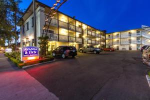 a parking lot in front of a building with a sign at Avania Inn of Santa Barbara in Santa Barbara