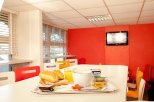 a tray with a plate of food on a table at Premiere Classe Strasbourg Ouest in Strasbourg