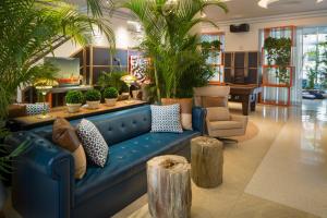 a blue couch in a lobby with palm trees at Generator Miami in Miami Beach