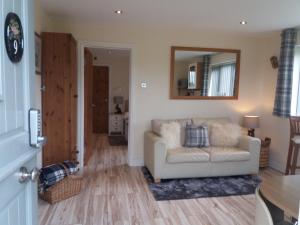 a living room with a couch and a mirror at The Stables - Deer Park Farm in Solihull