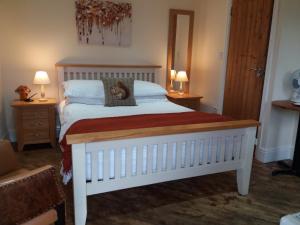 a bedroom with a bed with a teddy bear on a pillow at The Stables - Deer Park Farm in Solihull