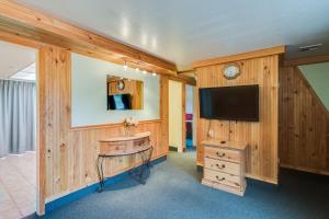 a room with a tv and a wooden wall at Zion Park Motel in Springdale