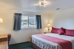 a bedroom with a bed with purple pillows and a window at Zion Park Motel in Springdale