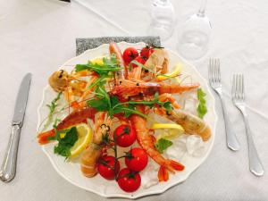 a plate of food with shrimp and vegetables on a table at Grand Hotel Lamezia in Lamezia Terme