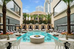 una piscina cubierta con mesas y sillas en un edificio en The Post Oak Hotel en Houston