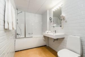 een witte badkamer met een wastafel en een douche bij Hestia Hotel Draugi in Rīga