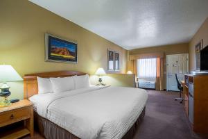 a hotel room with a bed and a television at Clarion Suites St George - Convention Center Area in St. George