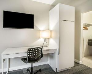 een bureau met een stoel en een televisie aan de muur bij Quality Inn & Suites By the Parks in Orlando