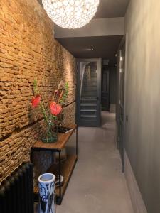 a hallway with a brick wall and a chandelier at Villa360 in Amsterdam