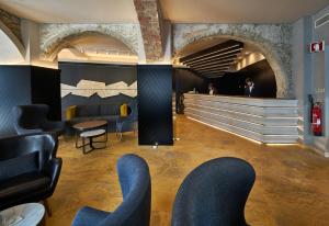 a waiting room with blue chairs and a staircase at My Story Hotel Tejo in Lisbon