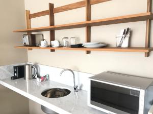 a kitchen with a sink and a microwave at AQ Tailored Suites in Buenos Aires