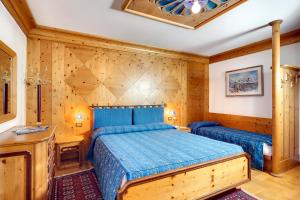 a bedroom with a bed and a wooden wall at Hotel Natale in Cortina dʼAmpezzo