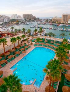 an overhead view of a pool with palm trees and a marina at U Magic Palace in Eilat